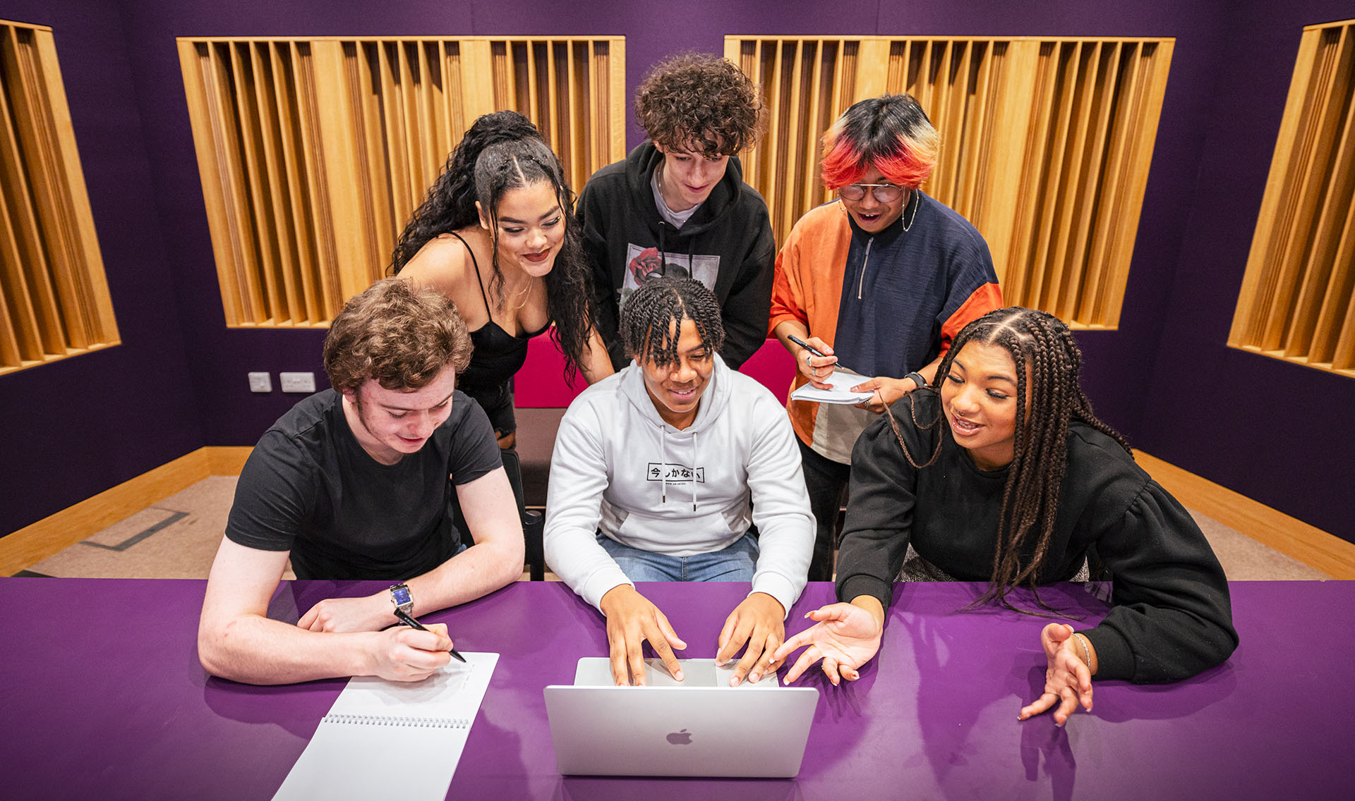 Music Business students-working at a table in a music studio